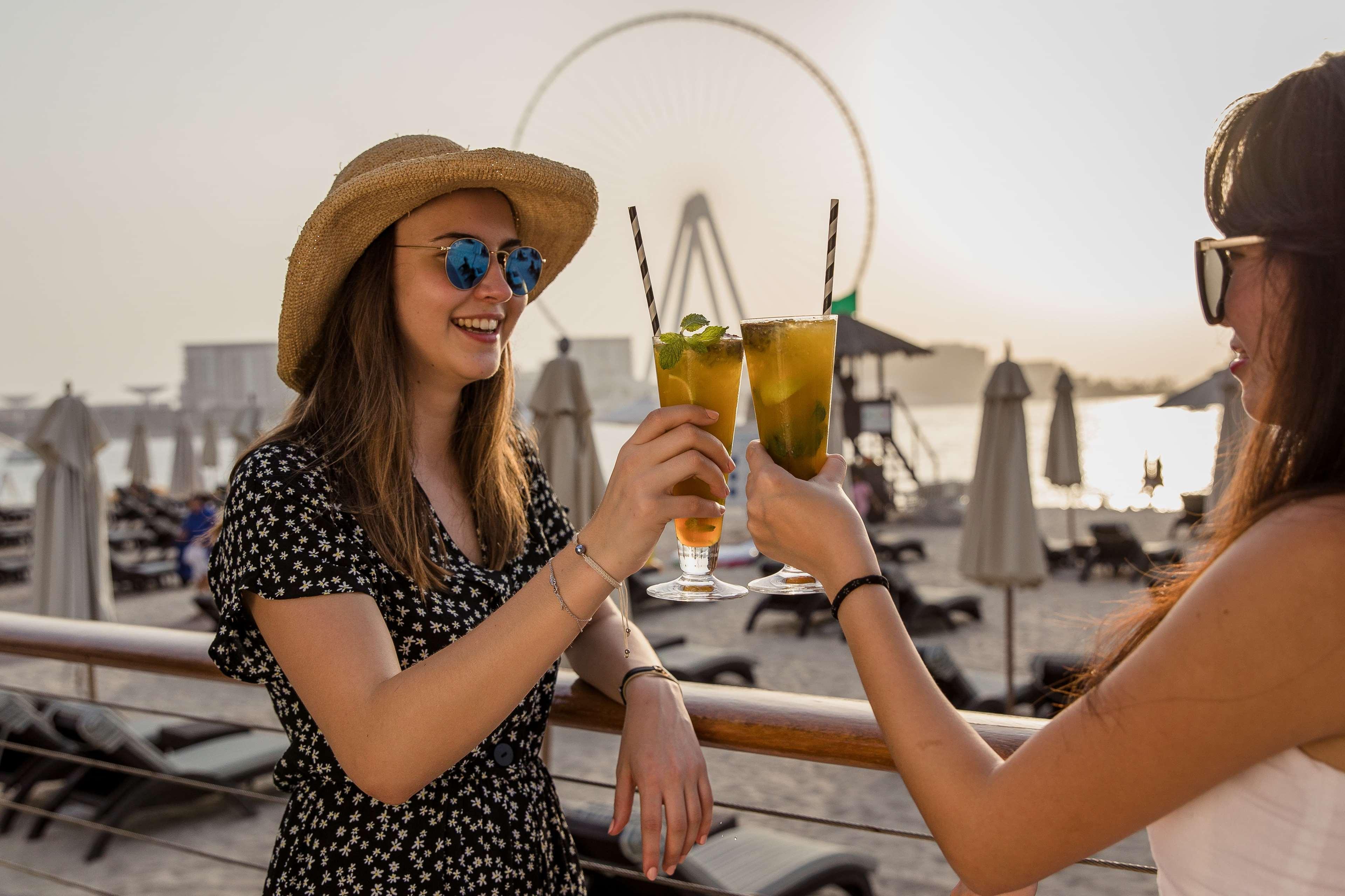 Hilton Dubai Jumeirah Exterior foto Two women toasting with cocktails